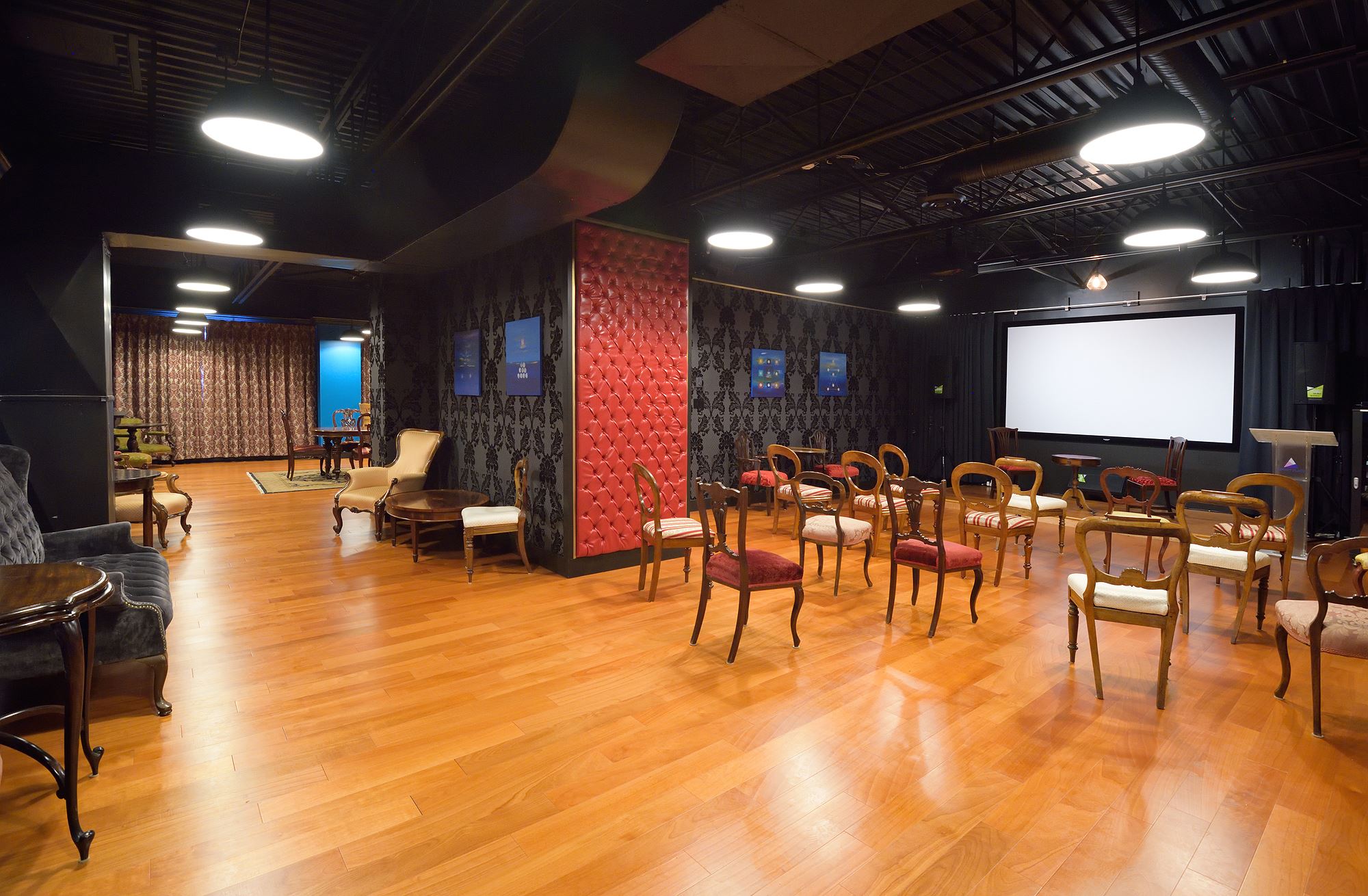Room 218 with wood floors, lounge seating and a projection screen